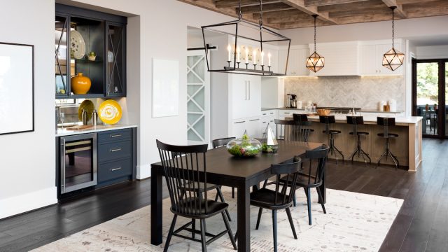 A modern farmhouse-style kitchen/dining room with a beamed ceiling