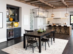 A modern farmhouse-style kitchen/dining room with a beamed ceiling