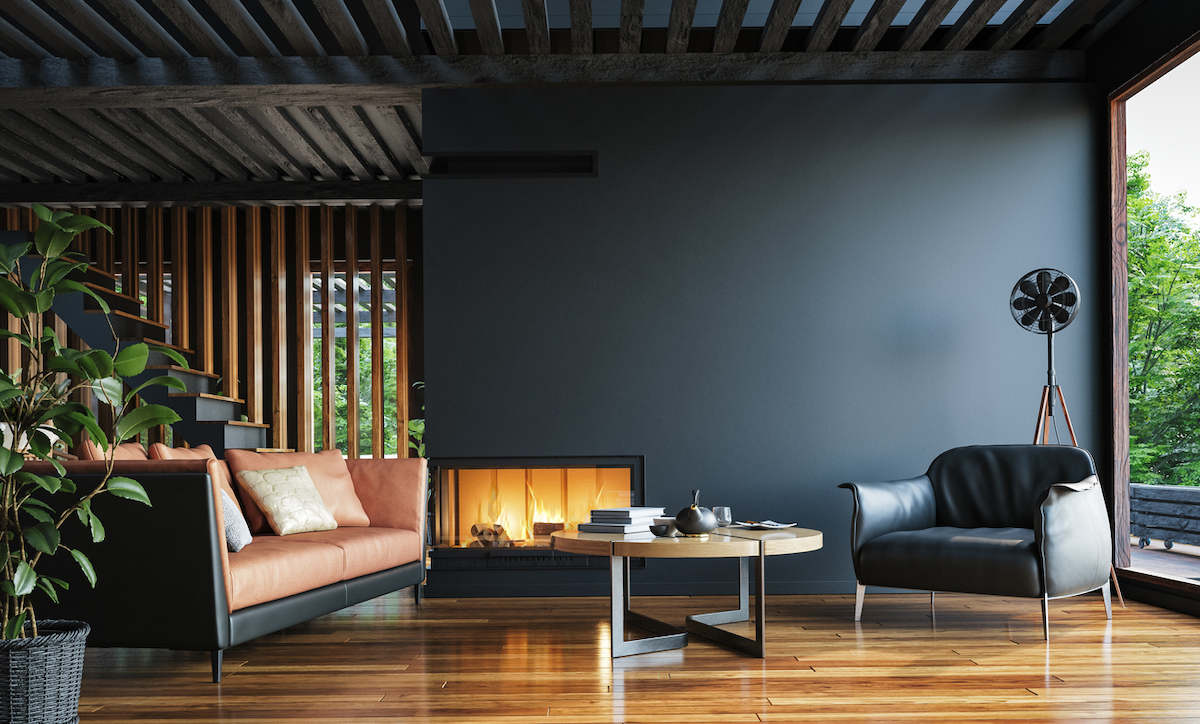Modern living room with dark walls, beamed ceilings, and a contemporary fireplace