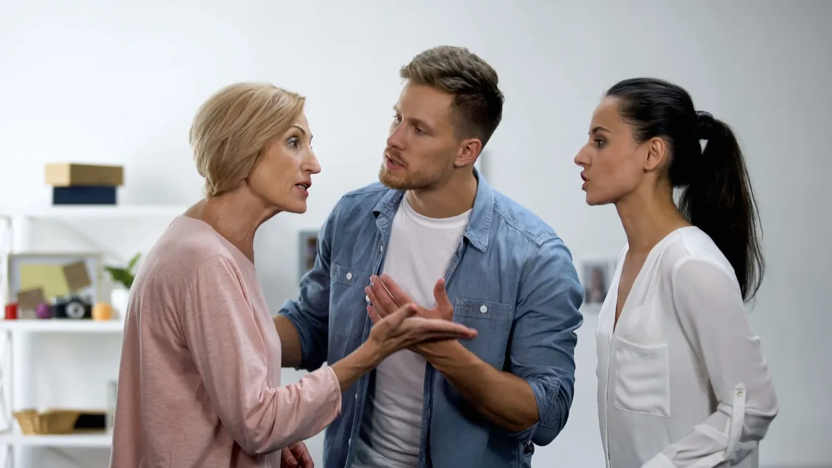 Young man settling conflict between mother and wife, family problems, quarrel