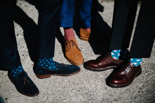 Groom's and groomsman feet with funny colorful socks. The men in stripy socks. Bright, vintage, brown shoes. Fashion, style, beauty.