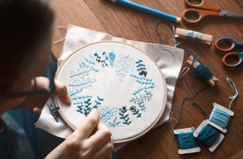 Cropped shot of an unrecognizable woman doing embroidery at home