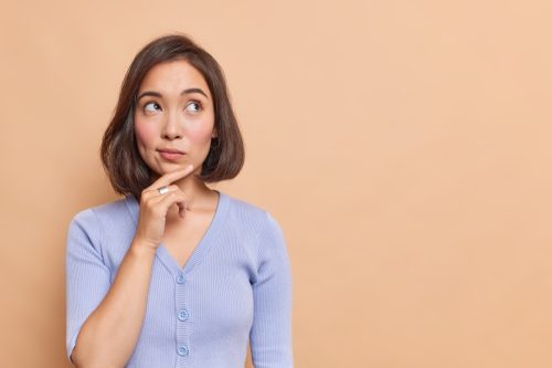 Thoughtful woman with finger on chin 