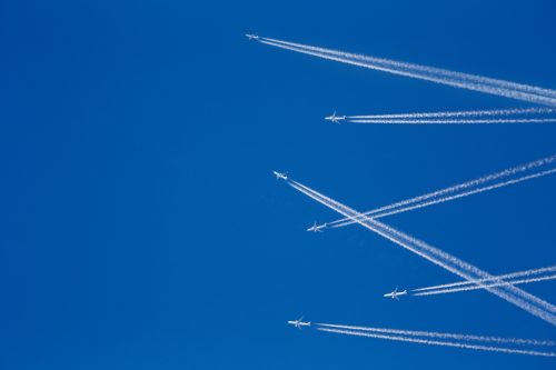 Multiple aircraft in the sky with chemtrail.