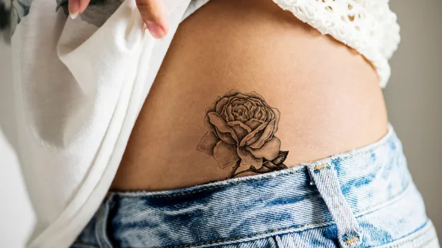 Closeup of lower hip rose tattoo on a woman