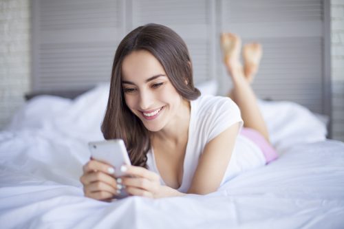 woman receiving a sext in bed