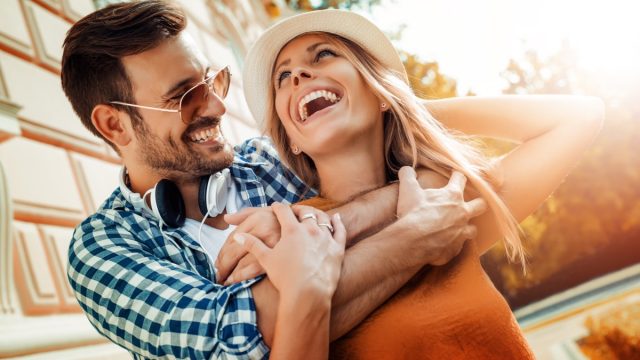 man and woman smiling and embracing outside in the sun