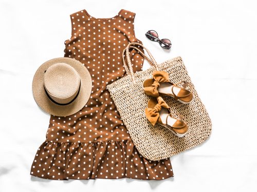 Summer style concept with sleeveless polkadot dress, straw hat, sunglasses, sandals and tote bag