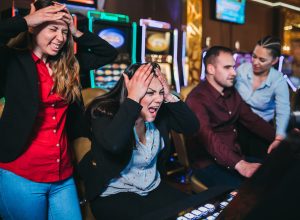 A group of friends playing slot machines with angry expressions after losing