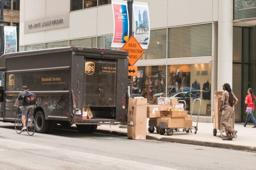 A man with UPS delivering boxes on LaSalle street in the Loop late in the day.