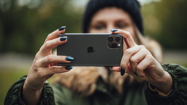 A person taking a photo using an iPhone