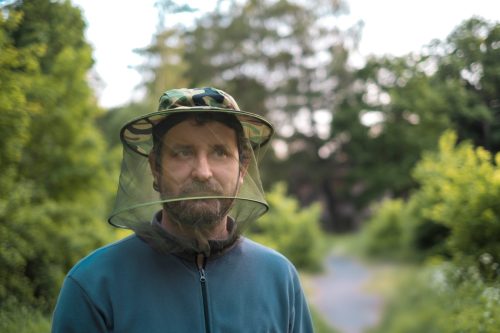 Man Outside with Mosquito Hat On