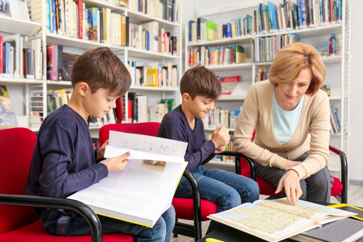 Teacher and children at school library