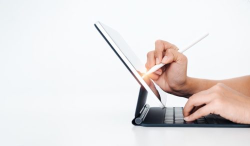 person drawing on their tablet against a white background