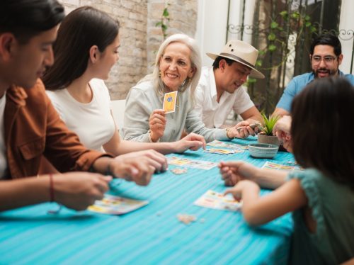 A smiling grandmother sitting with her family playing a game