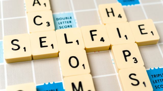 Close-up of the word "selfie" on a vintage Scrabble board