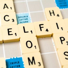Close-up of the word "selfie" on a vintage Scrabble board