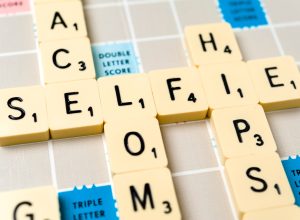 Close-up of the word "selfie" on a vintage Scrabble board