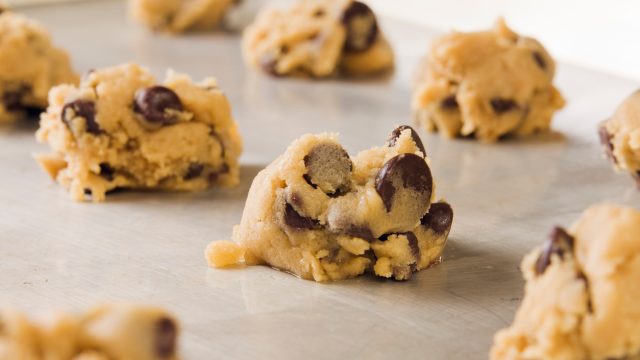 A close up of chocolate chip cookie dough pieces on a baking sheet