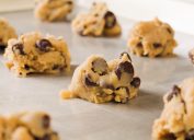 A close up of chocolate chip cookie dough pieces on a baking sheet