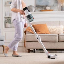 A person using a cordless vacuum in their living room