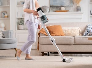 A person using a cordless vacuum in their living room
