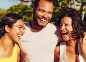 Man and two women laughing out in the sun