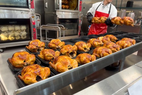 Sacramento, CA, USA March 24th, 2022 Costco employee cooking famous affordable roasted chickens