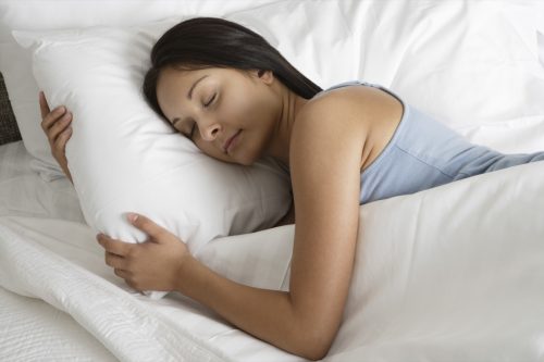 woman sleeping soundly with an extra pillow