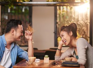 man and woman at a coffee shop exchanging flirty jokes