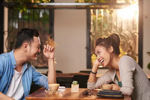 man and woman at a coffee shop exchanging flirty jokes