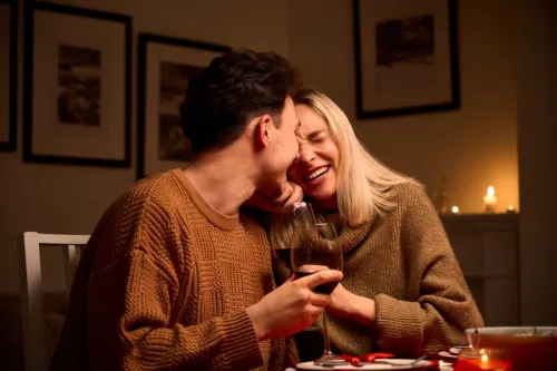 man and woman cuddling while drinking wine