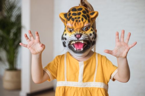little girl wearing a tiger mask on Halloween