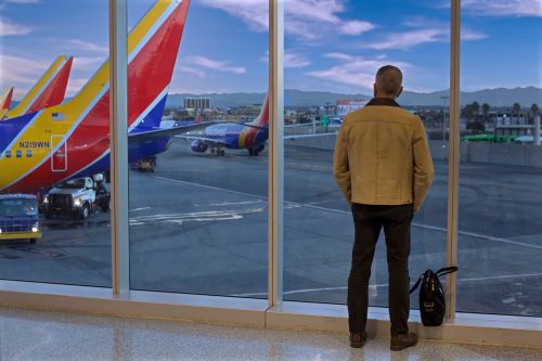 Southwest Airlines passenger watching planes from departure gate window