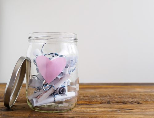 Jar with pink heart and rolled-up notepads