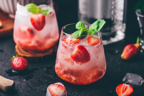 Two glasses of mocktails with fresh and frozen strawberry, and tonic
