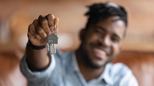 Man holding up the keys to a newly purchased home
