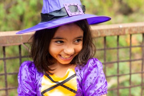 littel girl in a purple witches costume