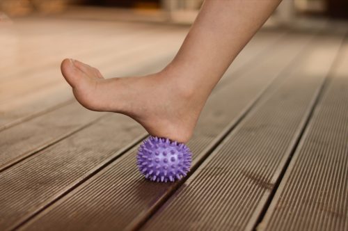 myofascial relaxation of the muscles of the foot with a purple ball at home,