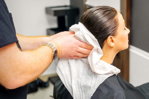 Woman getting hair towel dried at hair salon