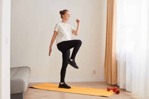 woman walking in place on yoga mat