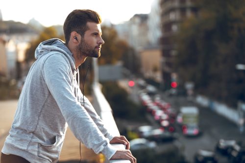 confident pensive man looking out at city