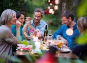 Group of middle aged friends at outdoor dinner party laughing