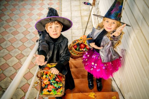 Happy children in a costumes of witches and wizards celebrating halloween