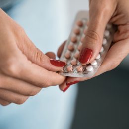 Close-up of woman holding a contraceptive pills. Concept of contraception methods.