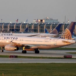 A United Airlines plane sitting on the runway at the airport with more United planes in the background