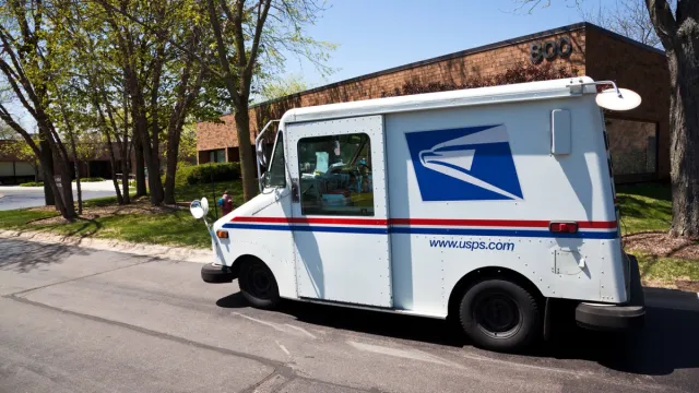 Northbrook, USA - May 14, 2013: United States Postal Service delivery truck distributing mail in office complex in Northbrook - suburban town north of Chicago.