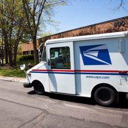 Northbrook, USA - May 14, 2013: United States Postal Service delivery truck distributing mail in office complex in Northbrook - suburban town north of Chicago.