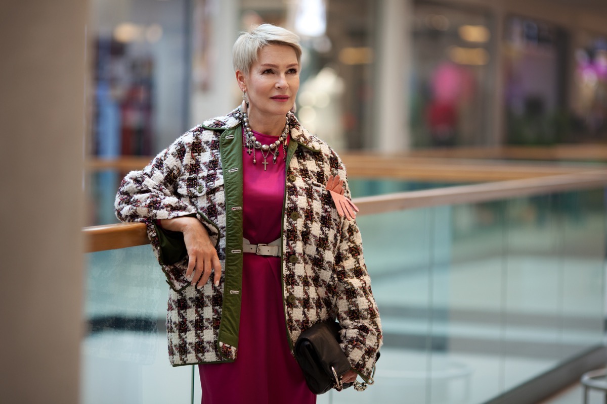 Mature woman fashion style. Portrait female model in fashionable clothes and accessories standing in public place