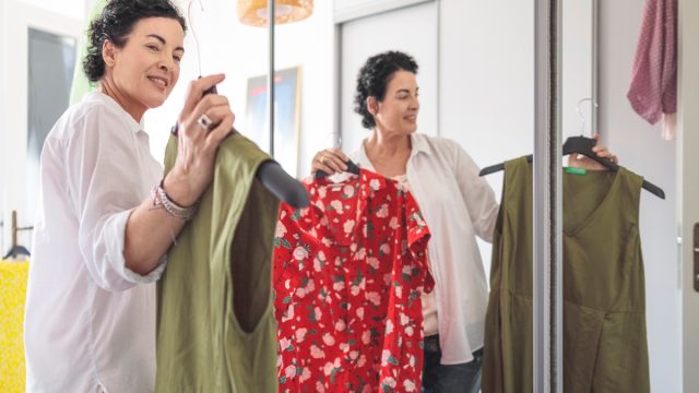woman looking at clothes in her wardrobe at home